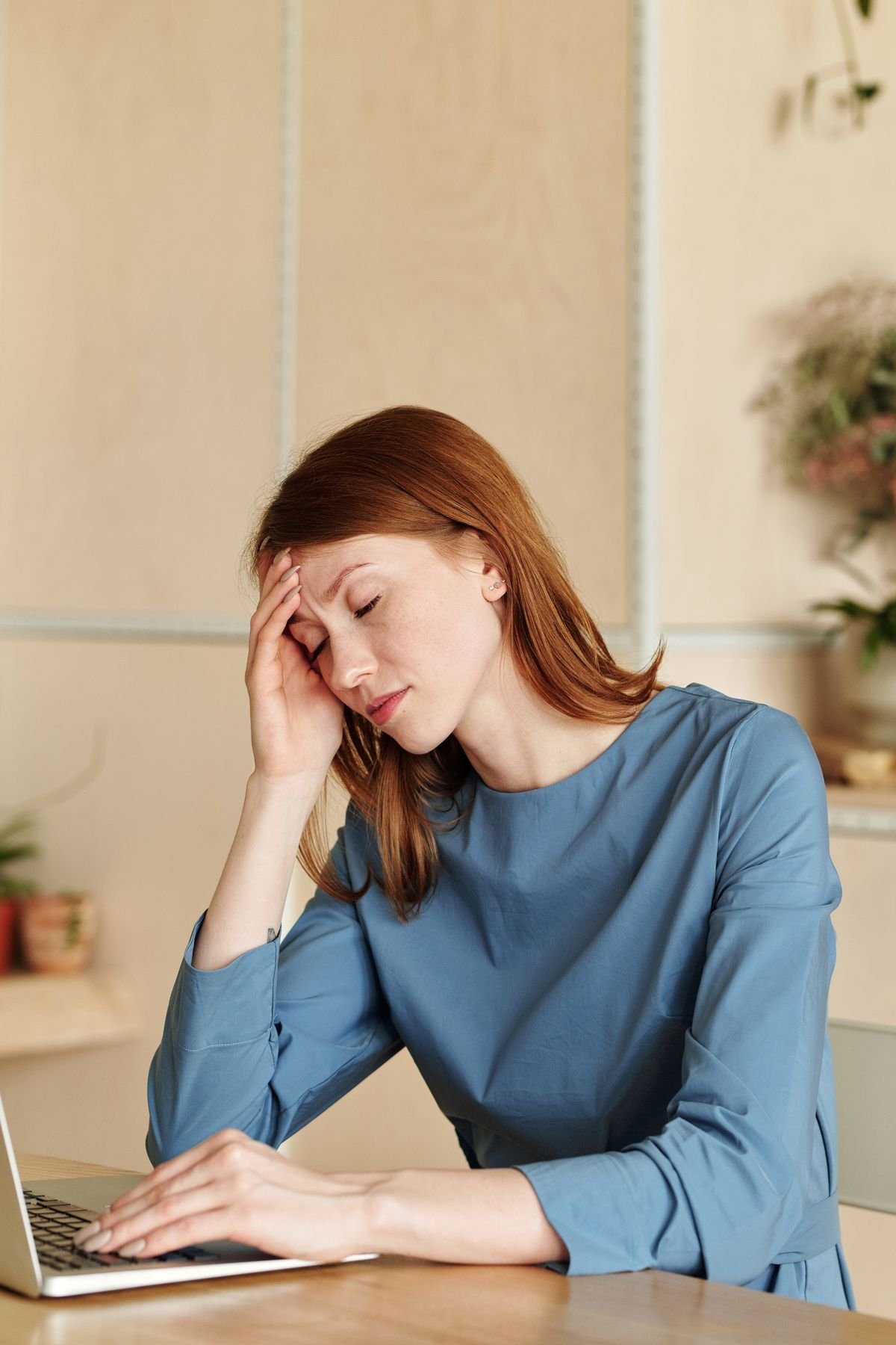 Stressed woman at home showing signs of caregiver burnout while caring for aging parents