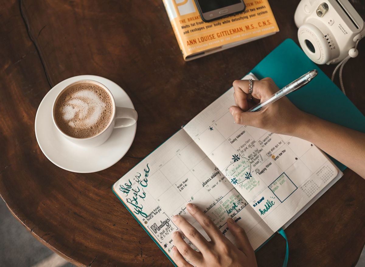 Journal and coffee on a table, journaling as self-care during divorce recovery