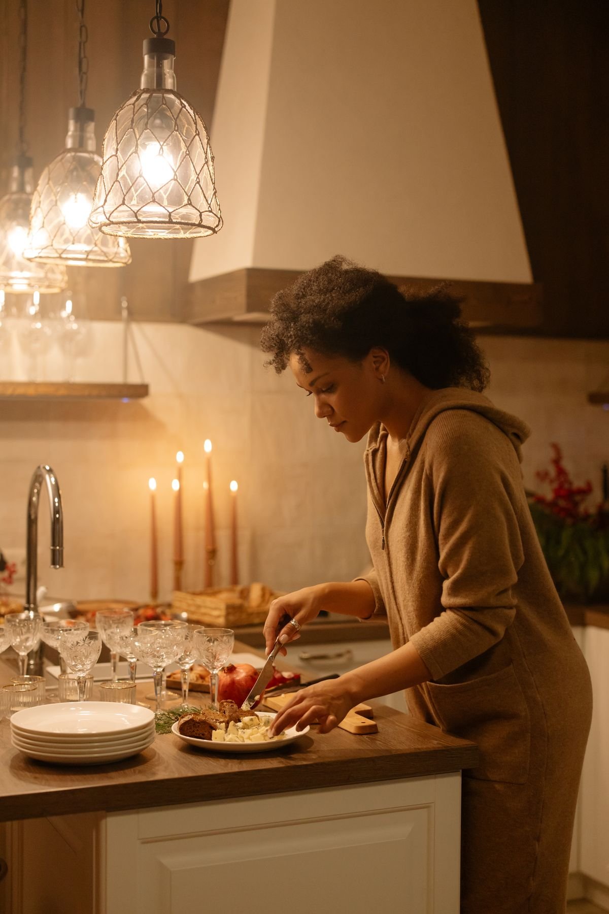Woman cooking a meal at home by candlelight as small, consistent self-care to prevent burnout