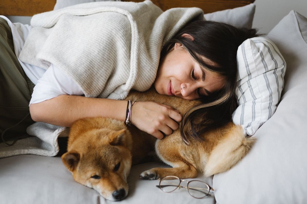 Woman resting on the couch with her dog, a simple self-care habit for burnout and overwhelm